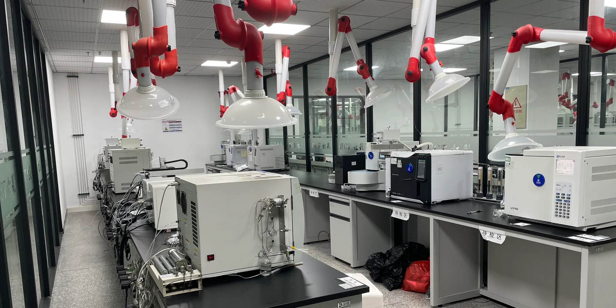 Analytical laboratory with overhead extraction arms and gas-connected instruments