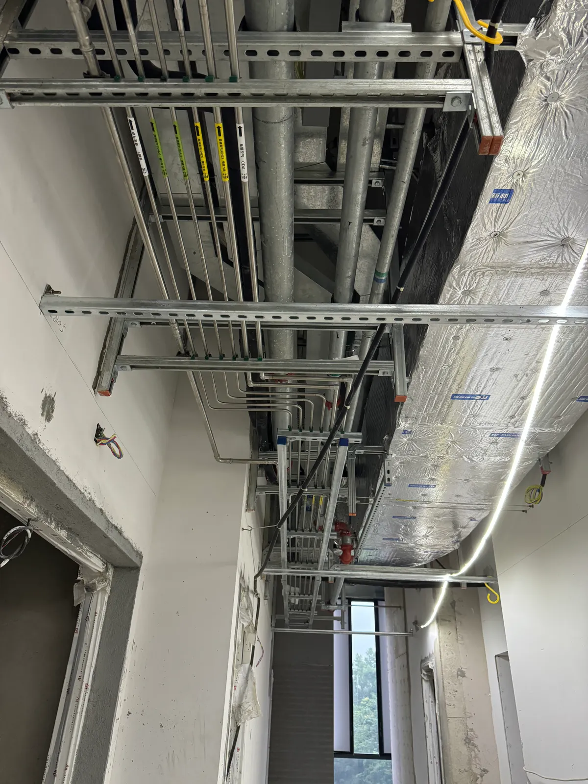 Supported laboratory specialty gas piping above a service corridor