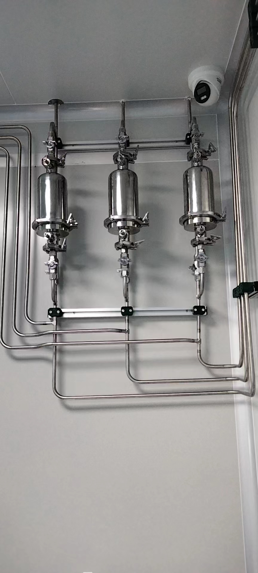 Installed stainless gas tubes and service assemblies on a clean laboratory wall