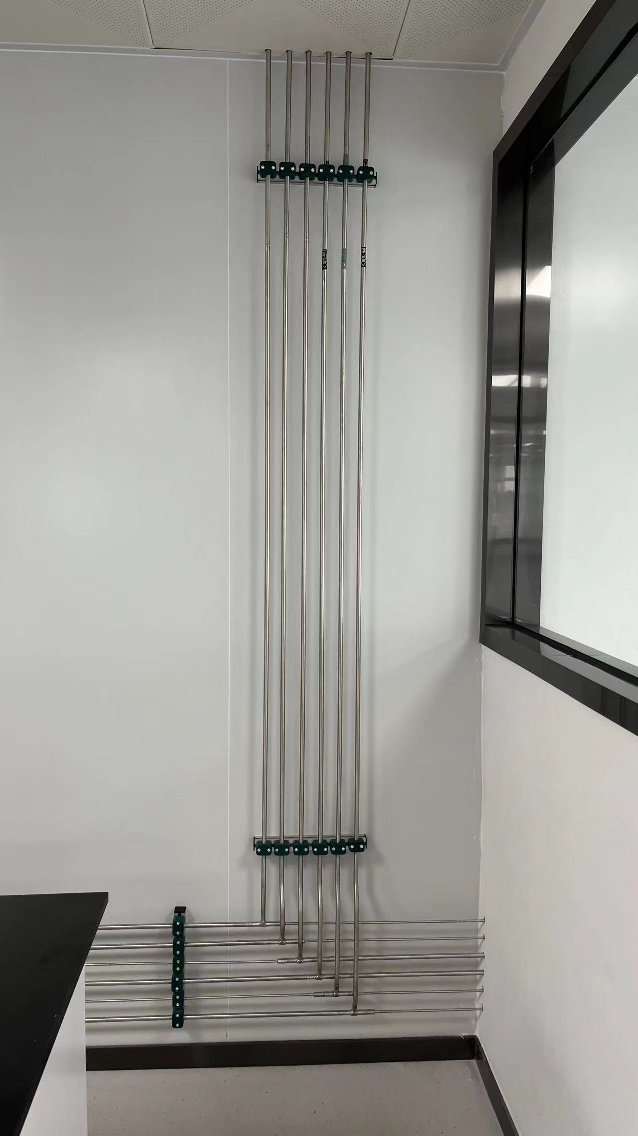 Stainless-steel laboratory gas lines routed along a wall